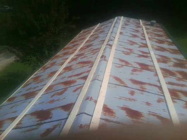 Rusted metal roof panels with new wood purlins before replacement — Storm Damage Roof Repair in Chatsworth by Roofing Brothers