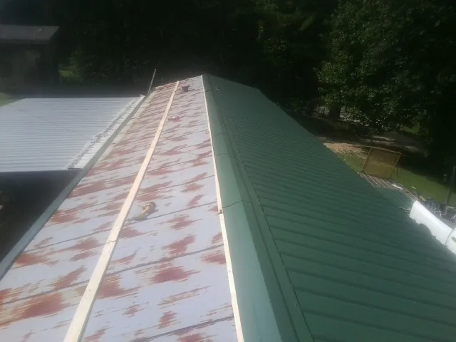 Old rusted panels beside newly installed green metal roofing — Wind Damage Roof Repair by Roofing Brothers in Chatsworth