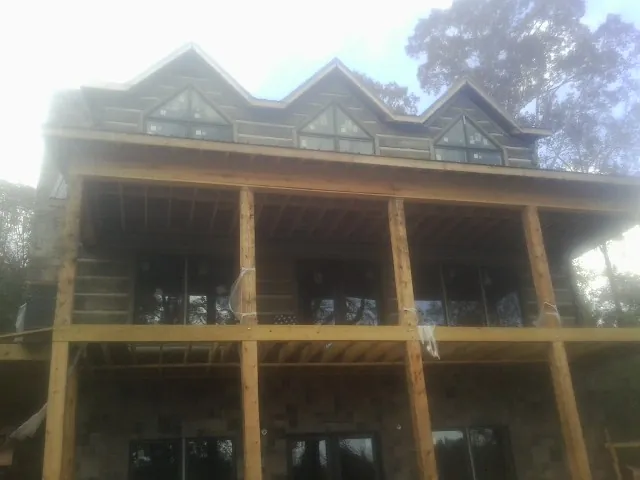 Dormers and porch framing on a large log home under construction — Roof Coating work by our crew in Chatsworth